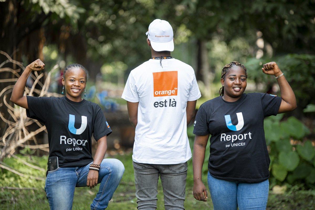 Trois jeunes engagés en t-shirts U-Report par UNICEF et Orange est là, poings serrés en signe de mobilisation